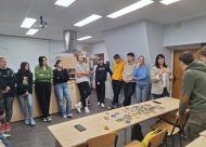 11. un 12. klases skolēni stāv pusaplī un klausās par studiju iespējām Vidzemes augstskolā
