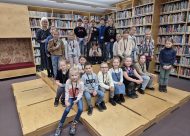 Bērni pie grāmatu plauktiem