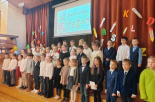 Skolēni stāv uz skatuves