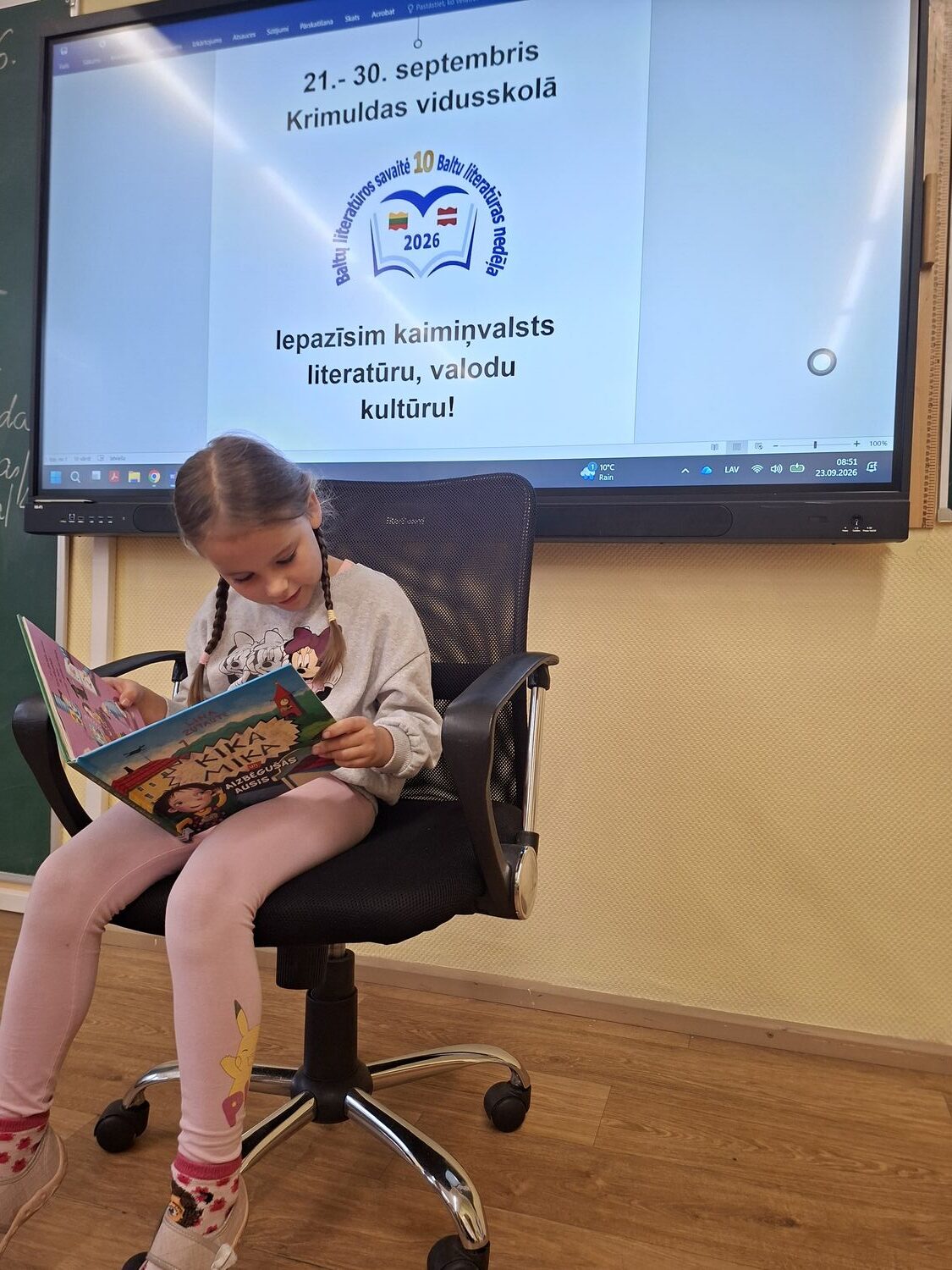 Meitene lasa grāmatu